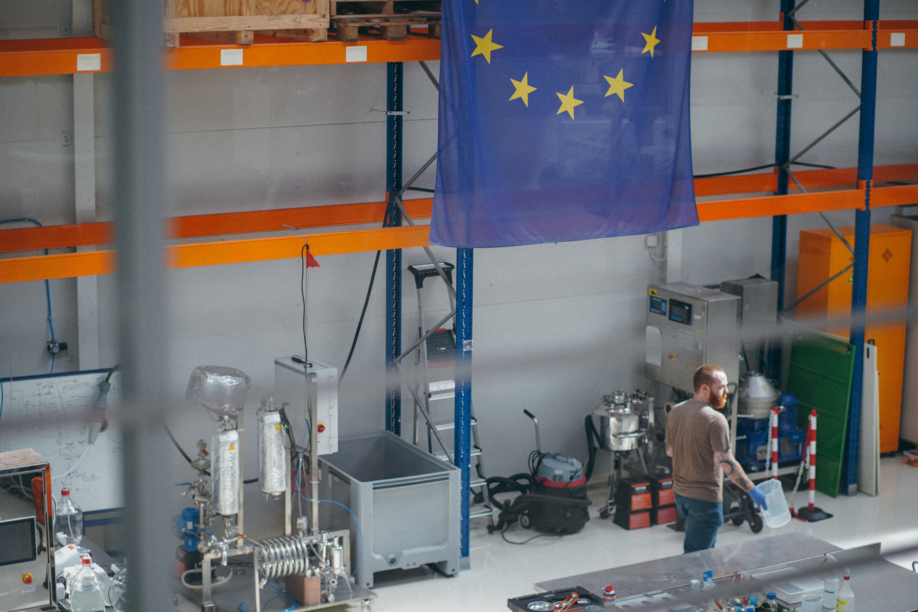 A colleague at the bench beside the vessels, the flag hanging above.